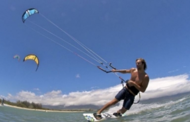 deslizandose en el agua mientras practica kitesurf